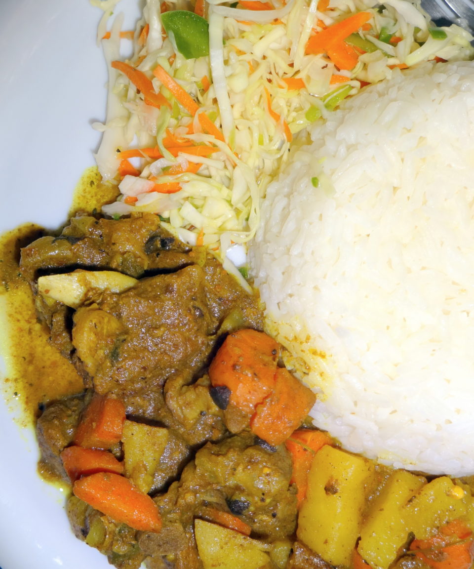 curry goat with white rice and Jamaican cabbage slaw