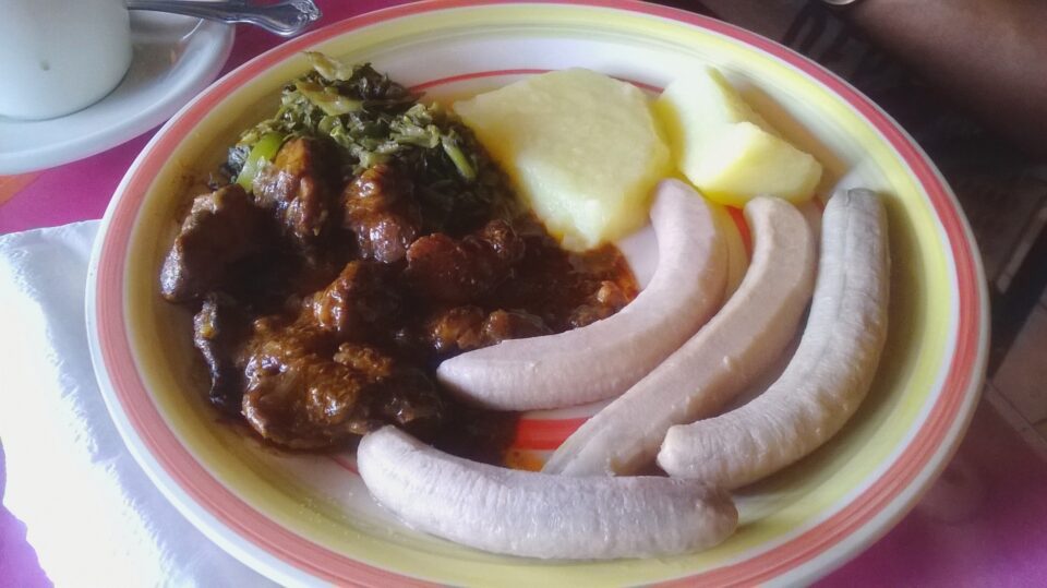 green bananas with stewed meat and yam on a plate